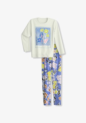 Top bianco a maniche lunghe con stampa floreale e testo "Les Alpes" abbinato a pantaloni del pigiama blu con motivo floreale.