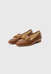 Mocassins en cuir marron avec un bout pointu, ornés d'une chaîne dorée sur le devant et d'un petit talon empilé. Texture lisse.