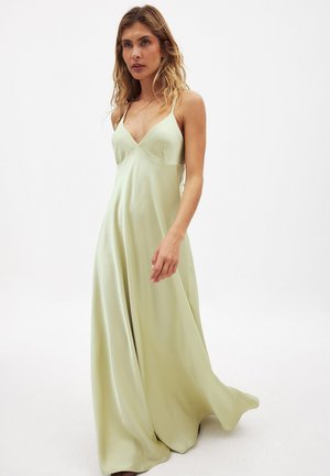 Saténové večerné šaty s voľnou siluetou, v výstrihu do V, nastaviteľnými ramienkami a svetlozelenou farbou.