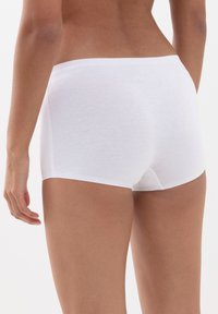 Vita bomullstrosor med en tät passform, med en enkel design och slät textur. Inga synliga mönster eller hårdvaruinslag.