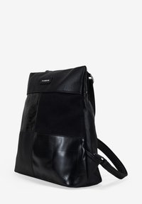 Mochila de cuero negro con un panel texturizado, con secciones lisas y con relieve de serpiente, cierre de cremallera y correa de hombro ajustable.