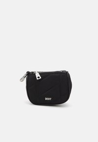 Svart vadderad DKNY-påse med en silverdragkedja, med en märkespräglad silverdetalj och kompakt rund form, tillverkad av textilmaterial.