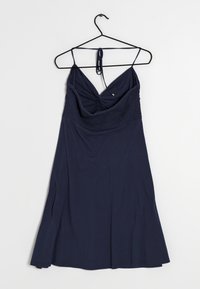 Mörkblå ärmlös klänning med tunna band, rynkad byst och utsvängd kjol hängande på en svart klädhanger mot en vit bakgrund.