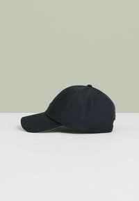 Tumesiniste värvi pesapalli müts, mis on valmistatud siledast kangast, millel on kumer visor, õmmeldud detailid ja ümar kroon koos ülemise nupuga.
