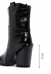 Stivale alla caviglia nero realizzato in materiale lucido con motivo coccodrillo, dotato di tacco a blocco di 8 cm e bordi superiori curvi.