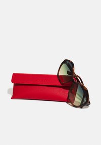 Ochelari de soare cu rame din broască țestoasă maro închis și lentile cu gradient. Vino cu un toc din piele roșie texturată.