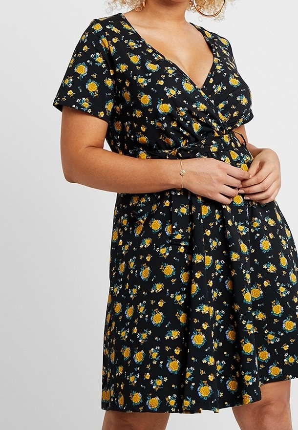 Black floral wrap dress featuring yellow roses and blue flowers, short sleeves, a V-neck, and a cinched waist with a flared skirt.