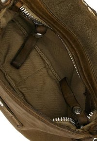 Interno di borsa in camoscio marrone con tessuto foderato, dotata di chiusura a zip e cinturini in pelle. Include un piccolo dettaglio logo in metallo.