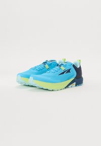 Des chaussures de course bleues et vertes avec un dessus en maillage texturé, une semelle rembourrée, un logo proéminent et un design de talon confortable.