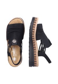 Czarne sandały z gładką skórzaną cholewką, elastycznymi paskami, okrągłym detalem w postaci guzika oraz teksturowaną podeszwą z warstwowym wzorem z korka.