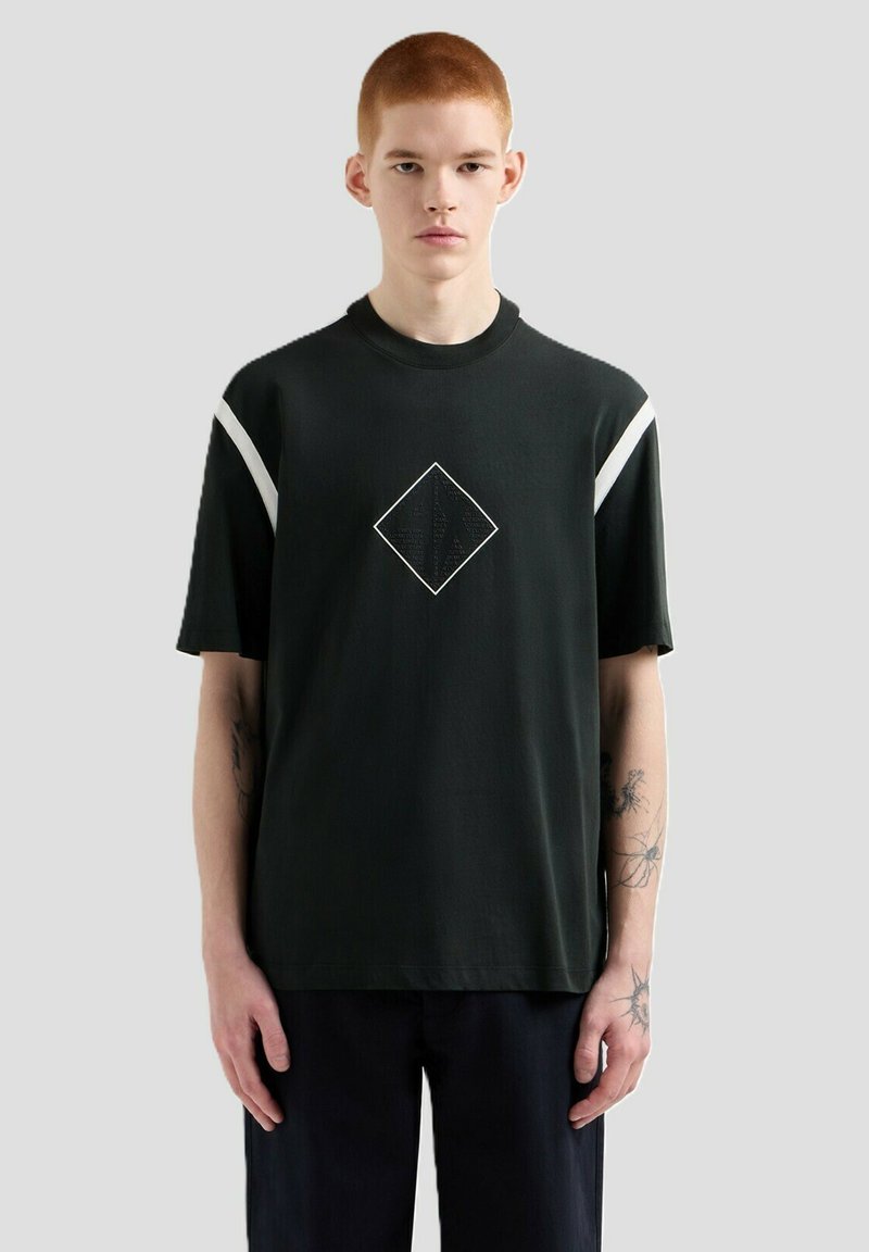 T-shirt nero a maniche corte con grafica a forma di diamante sul petto, strisce bianche sulle spalle e scollatura rotonda. Tessuto di cotone liscio.