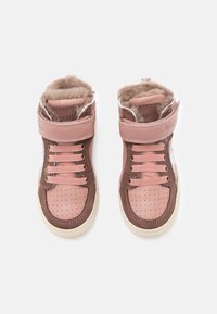 Baskets montantes roses et brunes avec une doublure en fourrure beige, des côtés perforés, des lacets en tissu et une sangle Velcro pour un maintien sécurisé.