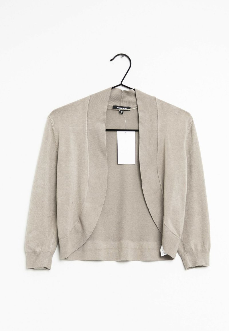 Cardigan beige appeso a un gancio con un design aperto, maniche lunghe e una texture liscia. Un'etichetta di abbigliamento è visibile all'interno.