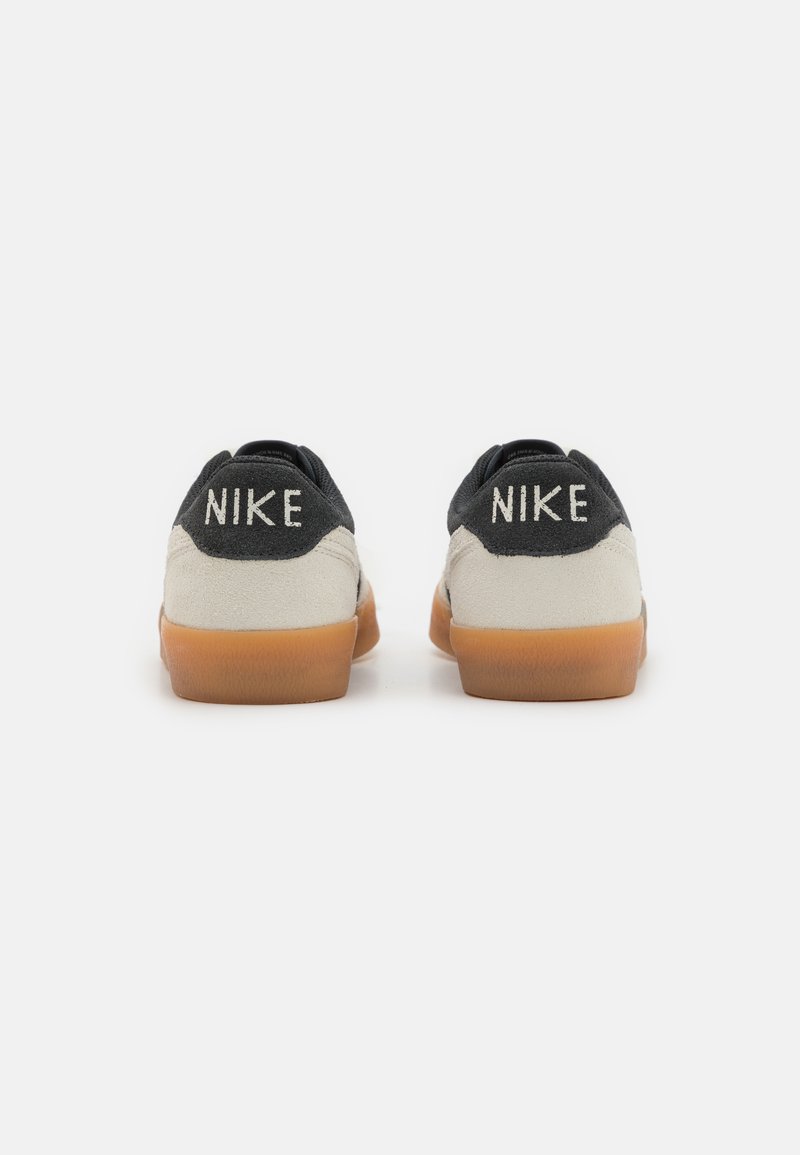 Czarno-kremowe sneakersy Nike wykonane z materiału zamszowego i gumowego, z podwójnym logo 'NIKE' na pięcie oraz gumową podeszwą.