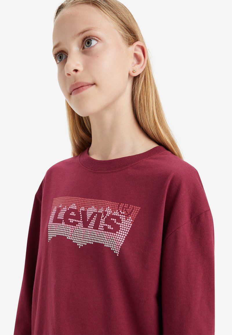 Bordeauxrotes Sweatshirt mit Rundhalsausschnitt und langen Ärmeln, das auf der Vorderseite ein großes Levi's-Logo in einem gepunkteten metallic Design zeigt.