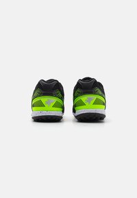 Pantofi sport negri cu accente verzi vibrante, partea superioară din plasă texturată și talpă din cauciuc. Prezintă un logo proeminent și modele distinctive pe lateral.