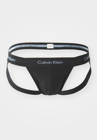 Schwarze Tanga-Unterwäsche aus weichem Stoff, mit einem breiten Taillenbund und hellblauem "Calvin Klein"-Logo, sowie einem minimalen Schnitt.