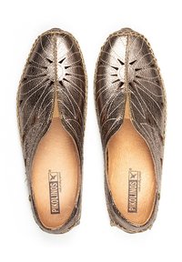 Chaussons en cuir bronze avec des découpes florales, des bords cousus et une semelle intérieure en cuir naturel. Présente un logo de marque embossé à l'intérieur.