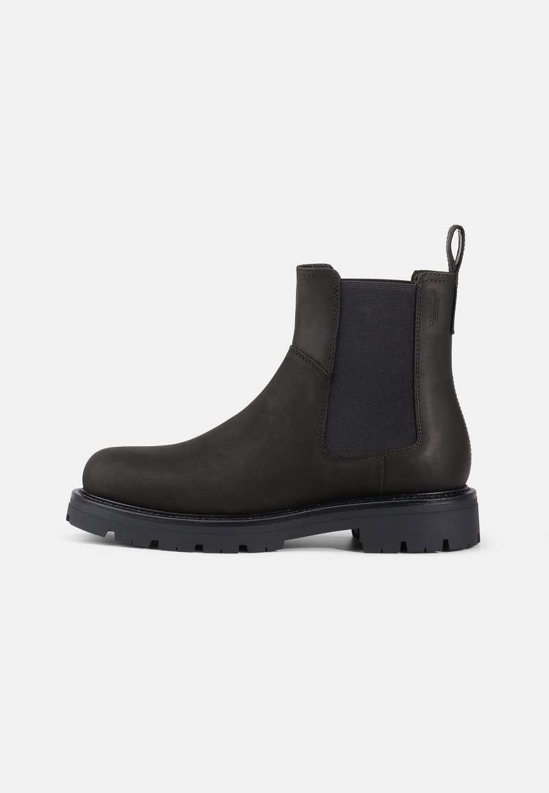 Botín Chelsea de cuero negro con paneles laterales elásticos, tirador y suela de goma texturizada para mayor agarre. Diseño elegante y acabado discreto.