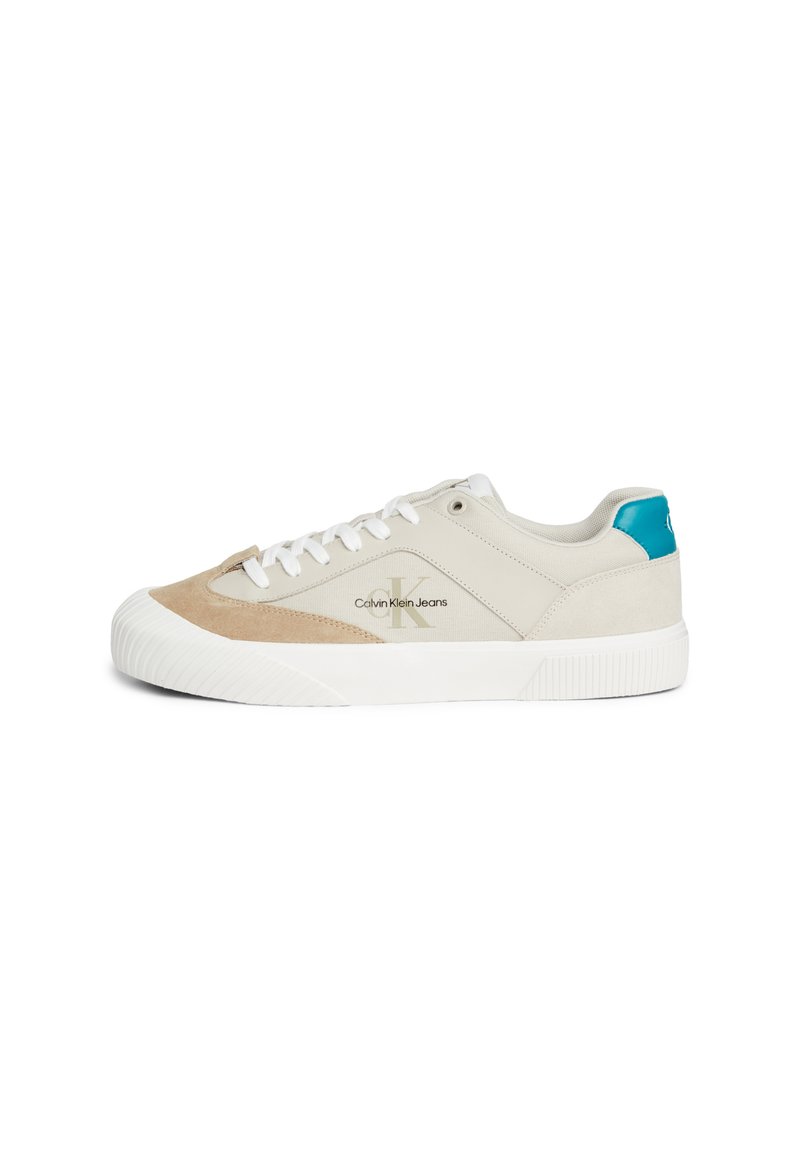 Sneakers z beżowym zamszem i szarym płótnem na wierzchu, białą gumową podeszwą i niebieskim akcentem na pięcie; mają białe sznurówki i szczegóły z logo.
