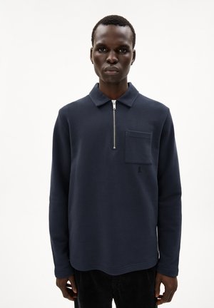 Navy pullover with long sleeves, zip collar, and front patch pocket; features soft fabric and a small logo in the corner.