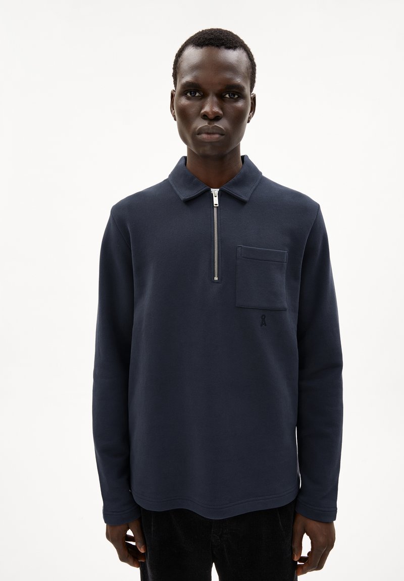Navy pullover with long sleeves, zip collar, and front patch pocket; features soft fabric and a small logo in the corner.