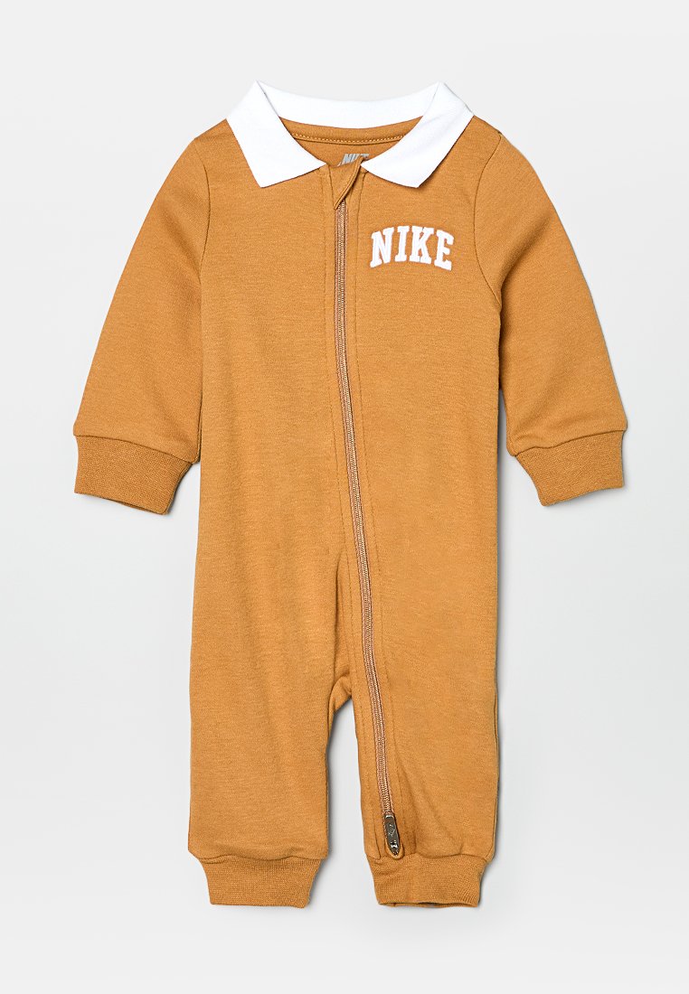 Combinaison une pièce couleur tan en tissu doux, dotée de manches longues, d'un col blanc et d'une fermeture éclair sur le devant avec un petit logo Nike sur la poitrine.