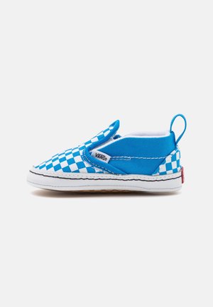 Blue slip-on shoe with a white checkerboard pattern, fabric upper, white rubber sole, and a small red logo detail on the heel.