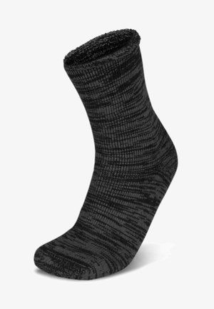 Schwarze gestrickte Socke mit einem strukturierten Muster. Verfügt über einen gerippten Bund und eine verstärkte Zehenpartie. Das Material wirkt weich und dick.