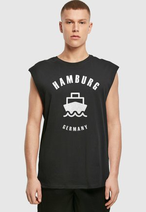 Black sleeveless T-shirt with white graphic featuring a boat and text “HAMBURG GERMANY,” made from soft fabric with a relaxed fit.