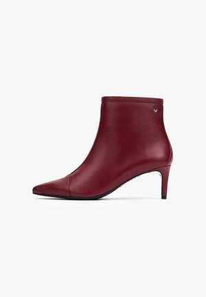 Bottine en cuir rouge avec un bout pointu, une silhouette élégante et un talon de 6,5 cm. Présente un design minimaliste et un petit accent de logo.