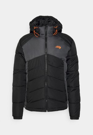 Black and gray puffer jacket with a zip front, elastic cuffs, and an adjustable hood with orange drawstrings. Features chevron stitching.