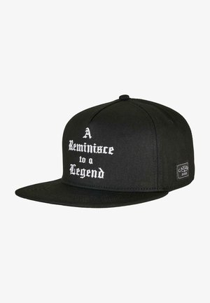 Cappellino snapback nero con visiera piatta, con testo bianco che recita "Un Ricordo di una Leggenda." Include un'etichetta di marca sul lato.