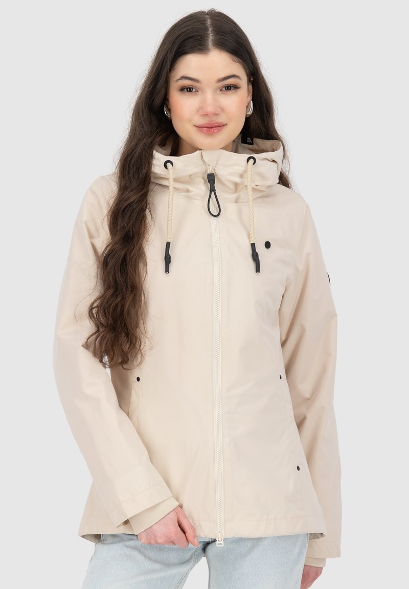 Giacca impermeabile beige chiaro con cappuccio, zip frontale e cordoncino. Presenta dettagli neri e tasche a mano. Texture liscia.