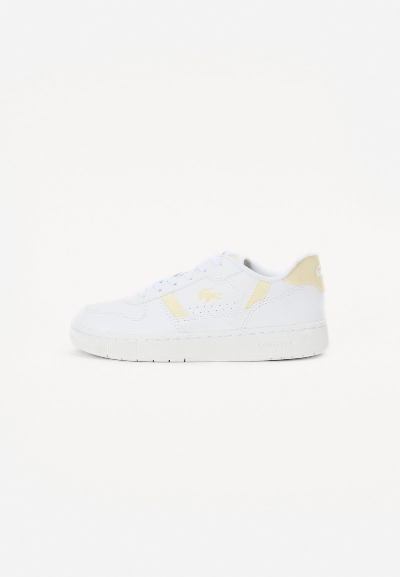 Valged sneakerid kollaste aktsentidega, valmistatud siledast nahast. Omab ümarat varvast, nööridega disaini ning brändi detaile küljel ja kandadel.