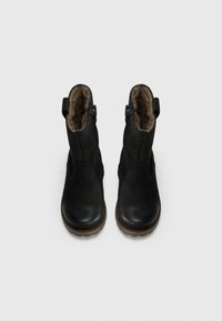 Bottines en cuir noir avec une doublure en fourrure douce, des fermetures éclair sur les côtés et une finition texturée. Semelles en caoutchouc avec un léger talon.