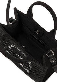 Schwarze Stoffhandtasche mit strukturiertem Vorderteil und glänzenden Beschlägen. Verfügt über eine offene Oberseite, ein Innenfach und kleine Griffe zum Tragen.