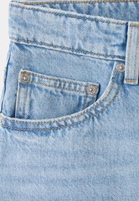 Light blue denim jeans pocket with orange stitching and metal rivets on a small coin pocket and belt loop.