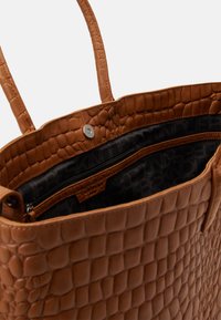 Hnědá tote taška s kroko vzorem, hladkým povrchem, s dvěma uchy, magnetickým zavíráním a vnitřní kapsou na zip.