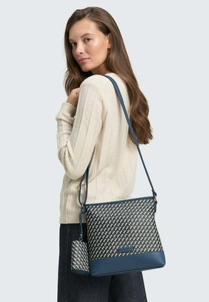 Blaue und cremefarbene gewebte Handtasche mit einem strukturierten Muster, ergänzt durch eine passende kleinere Tasche mit einem glatten, lederähnlichen Boden.