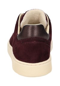 Burgunderfarbenes Wildleder-Sneaker mit einem glatten braunen Lederabsatz, cremefarbenem Innenfutter und einer strukturierten Gummisohle. Minimalistisches Design und Nahtdetails.