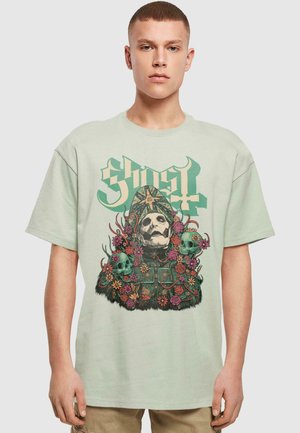 Light green cotton t-shirt featuring a skull graphic with flowers and skull accents. Short sleeves, relaxed fit, detailed front design.