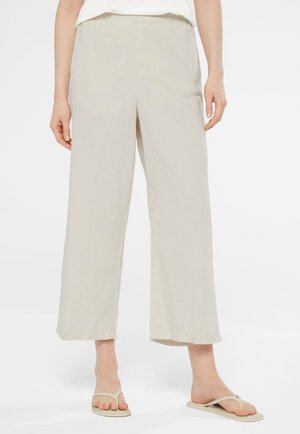 Beige, leichte Leinenhose mit elastischem Bund und weitem Bein, die eine glatte Textur und kein sichtbares Muster aufweist.