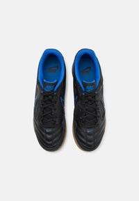Črne Nike superge z modrimi akcenti, teksturirano sintetično zgornje, vezalni dizajn, podložen ovratnik in gumijast podplat z vidnim vzorcem za oprijem.