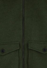 Donkergroene fleecjas met een rits aan de voorkant, twee opgestikte zakken aan de voorkant en zwarte knoopaccenten. Zachte textuur, getailleerde vorm en functioneel ontwerp.