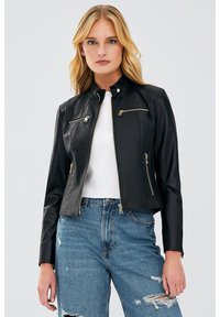 Black faux leather jacket with a stand-up collar, two zipped chest pockets, and two side pockets; styled with a fitted design and gold hardware accents.