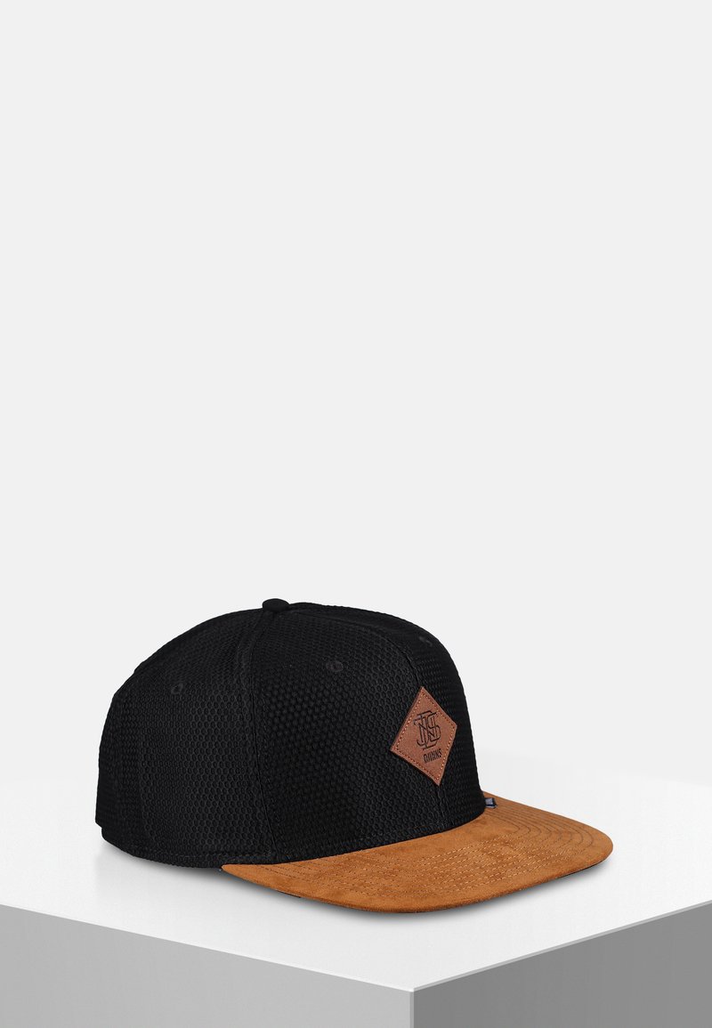 Svart mesh cap med en brun semsket skjerm og en diamantformet lærlapp på forsiden. Har buet skjerm og teksturert overflate.
