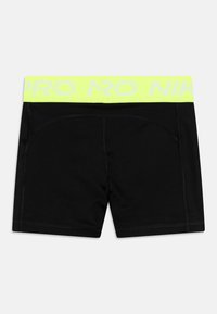 Czarne sportowe szorty z elastycznego, gładkiego materiału. Posiadają neonowożółty pas z napisem "NIKE PRO" nadrukowanym białym kolorem.