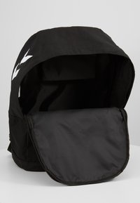 Zaino nero con chiusura a coulisse e ampia apertura. Presenta un tessuto liscio e resistente e un logo bianco sul davanti.