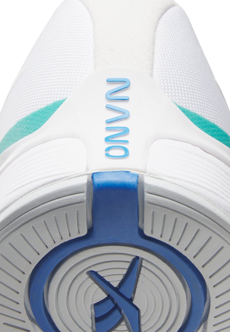 Zapatilla deportiva blanca con parte superior texturizada, acentos en color aqua y una suela de goma azul circular con detalles concéntricos y logotipo.